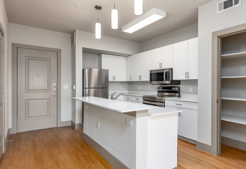 A kitchen with white cabinets and a white island.